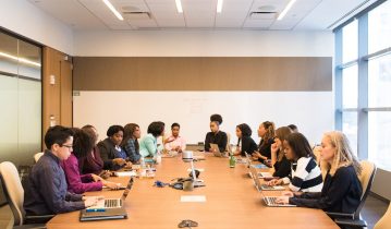 group of people having a meeting, and seating around a big table