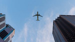 airplane in the sky flying over buildings