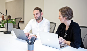 two colleagues working with laptops