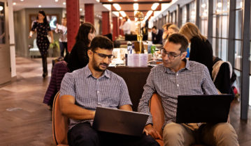 Cynozure team on laptops discussing DataOps