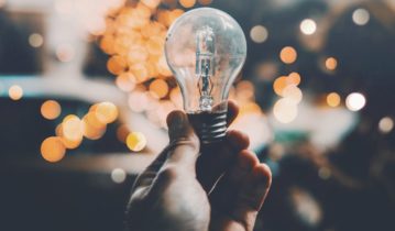 a hand holding a light bulb