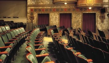 Old theatre with empty green chairs