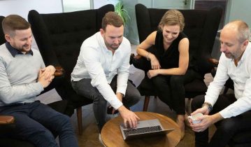 Cynozure directors seating around a table and looking at a laptop