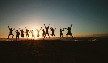 People jumping for joy at sunset